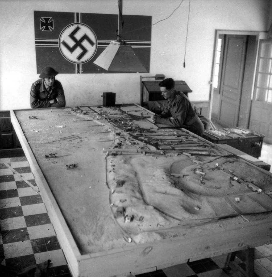 Soldados aliados mirando una maqueta de los nazis con el sector de la Playa de Sword del desembarco de Normandía