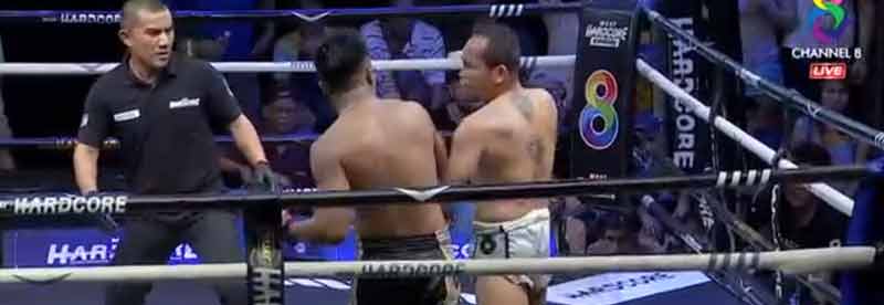 Un árbitro de Muay Thai amortigua la caida de un luchador que cae KO