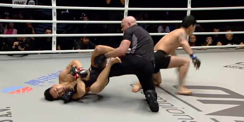 Un luchador de MMA lucha con la pierna del árbitro cuando queda atontado en el combate