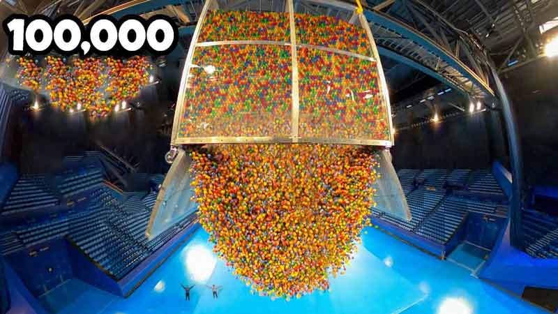 Dejando caer 100.000 pelotas de goma en una cancha de deportes