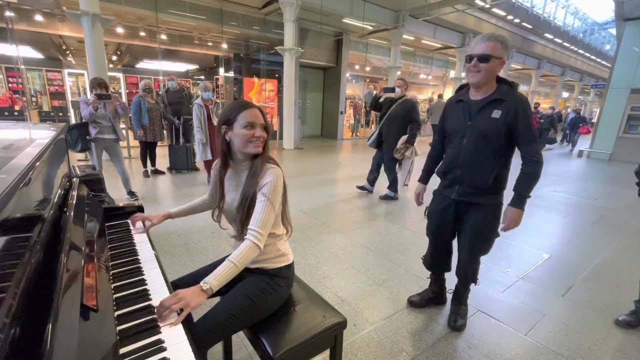 Tocando a cuatro manos el piano en la estación