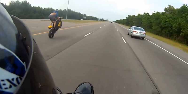 Haciendo caballitos con la moto a gran velocidad por una carretera pública