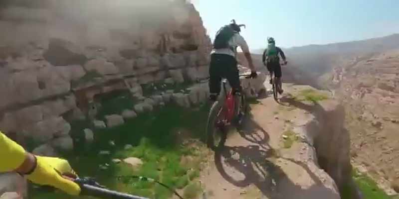 Unos ciclistas bordean un acantilado cuando uno de ellos se cae desde gran altura