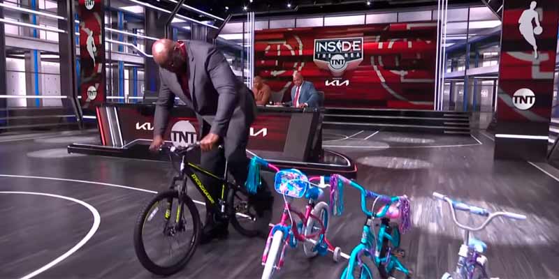 Shaquille O'Neal es retado a montarse en distintas bicicletas de niños